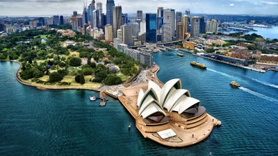 Vue aérienne de Sydney présentant l'emblématique Opéra de Sydney et le Pont du Port de Sydney, entourés par la vibrante ligne d'horizon de la ville et les eaux tranquilles de Port Jackson.