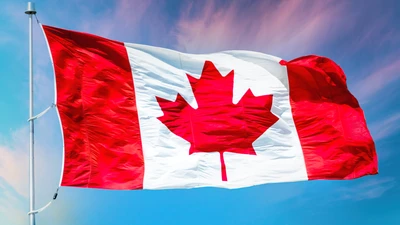 Vibrante bandera de Canadá ondeando contra un cielo azul