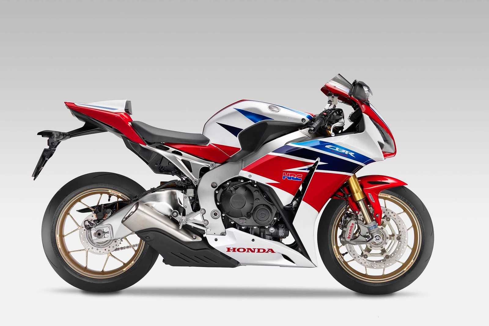 A close up of a red, white and blue motorcycle on a white background (motorcycle, car, motorcycle fairing, honda, automotive exterior)