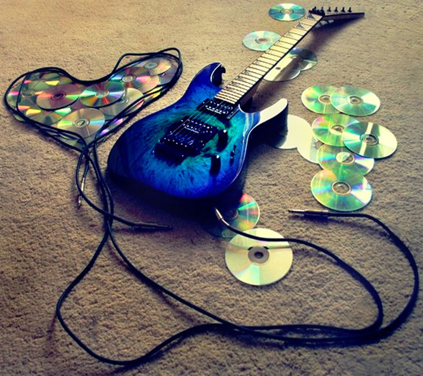 Uma guitarra árabe com uma corda e um estojo de guitarra e vários cds (azul, cd, legal, violão, coração)