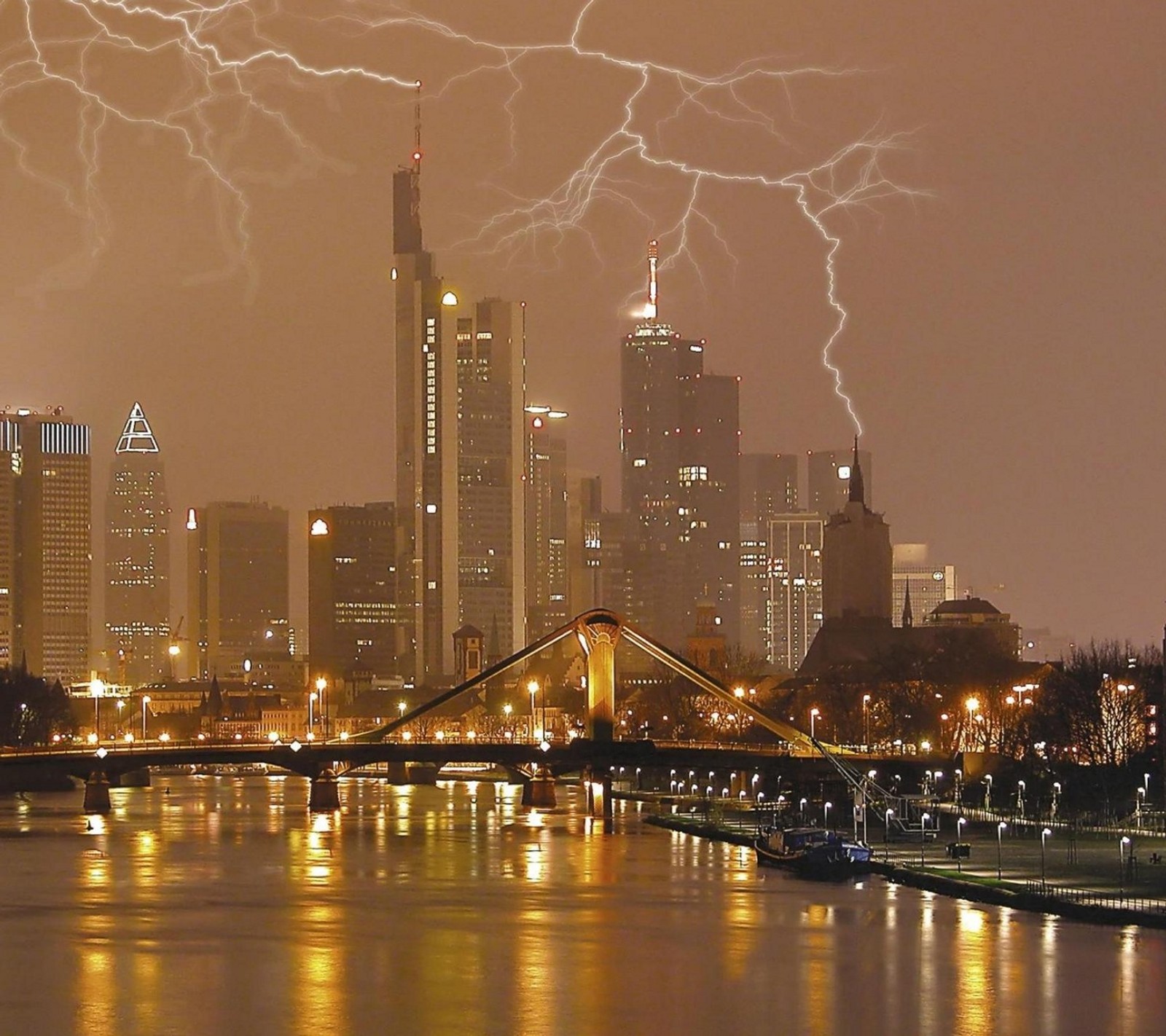 Un éclair frappe au-dessus de la ligne d'horizon d'une ville avec un pont (ville, éclair, tempête)