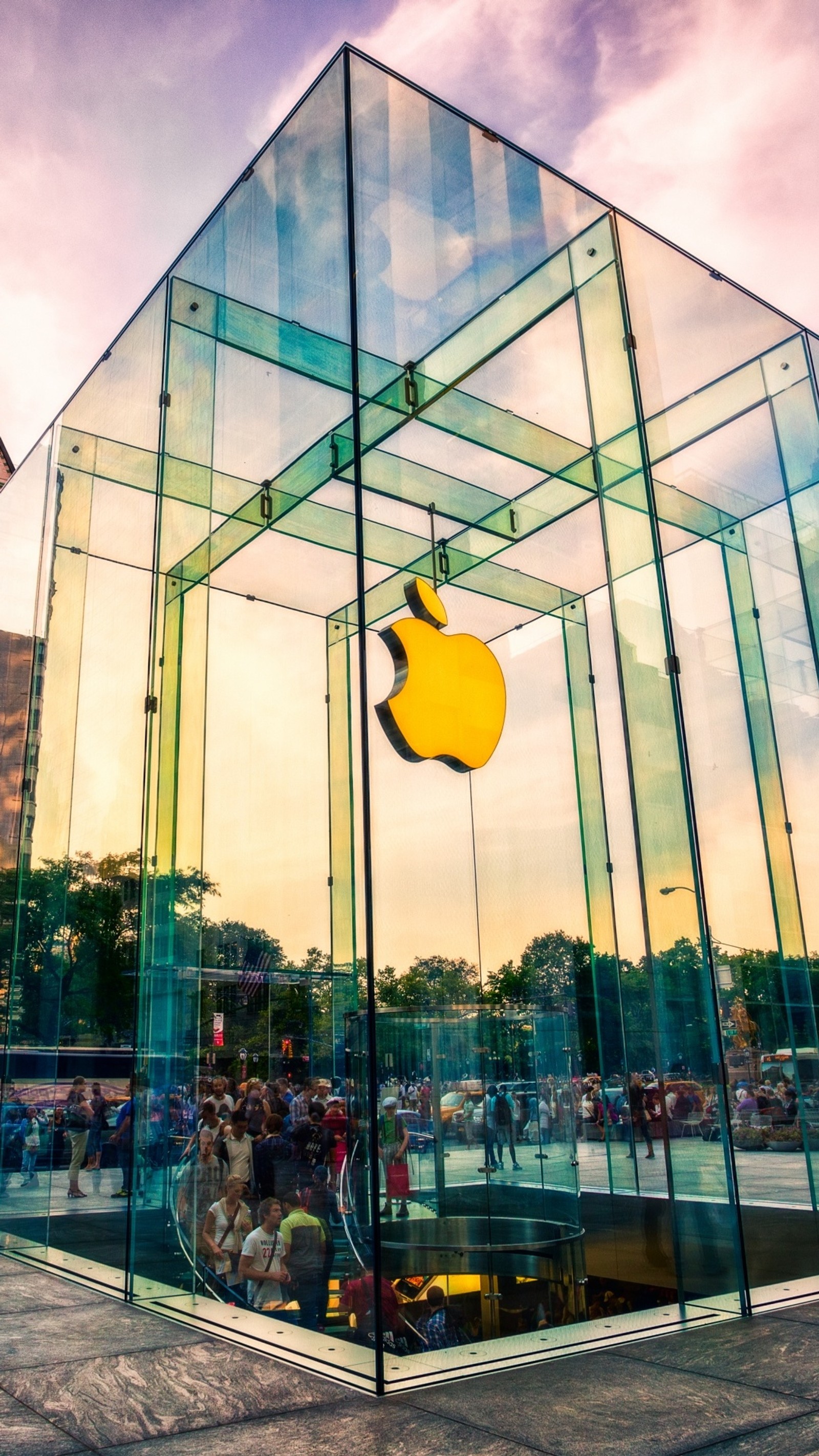 There is a glass box with a yellow apple inside of it (apple, glass, logo, store)