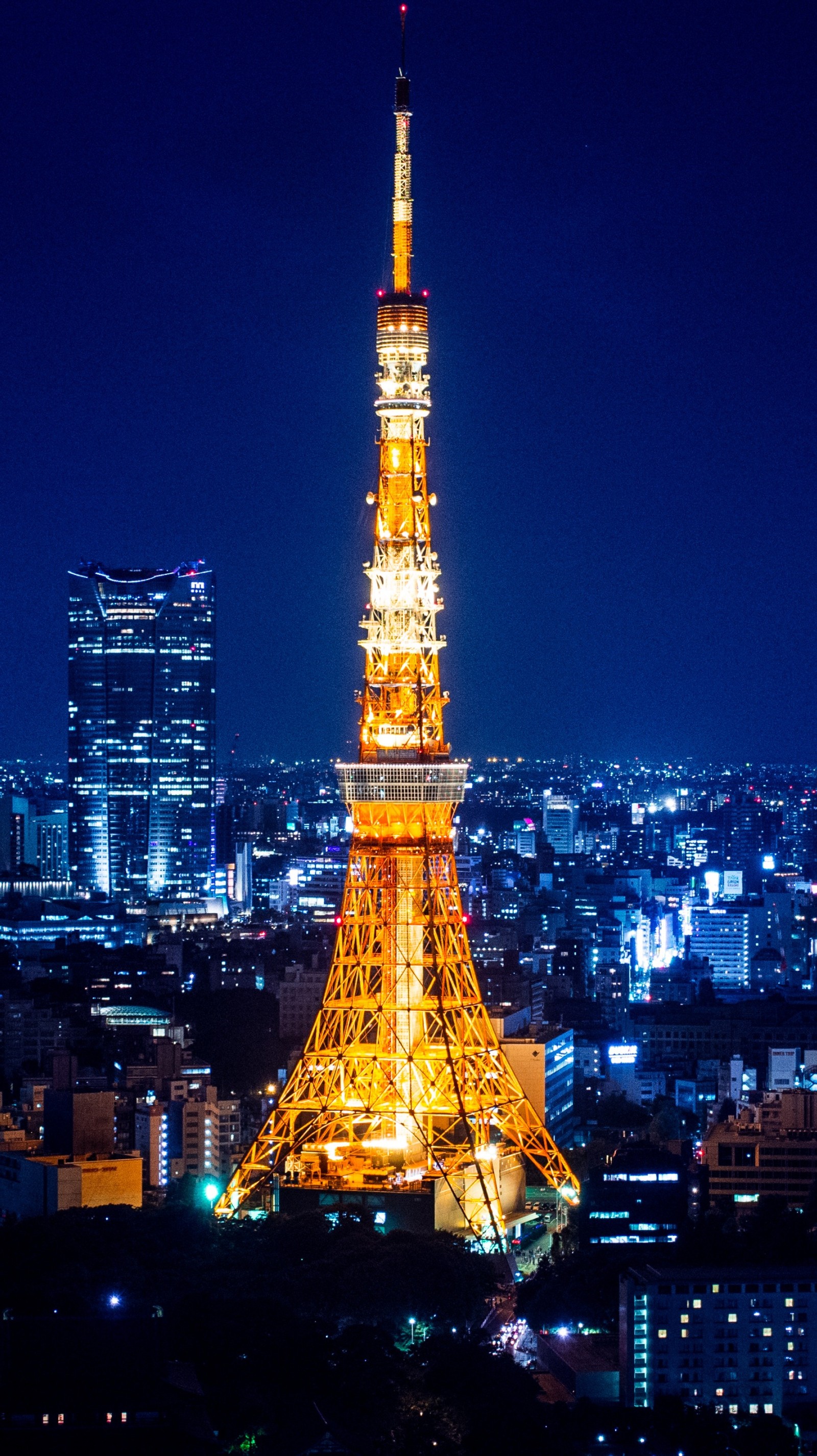 Uma vista aérea de uma cidade à noite com uma torre alta (japão, torre de tóquio, tokyo tower)