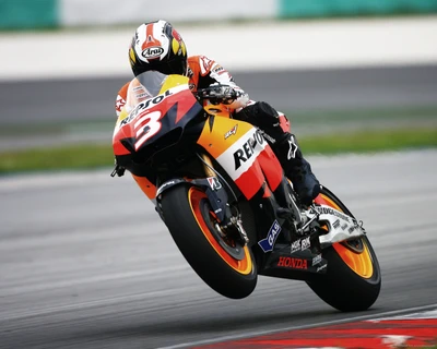 Dani Pedrosa in Aktion auf einem Repsol Honda Motorrad, das während eines MotoGP-Rennens einen beeindruckenden Wheelie zeigt.