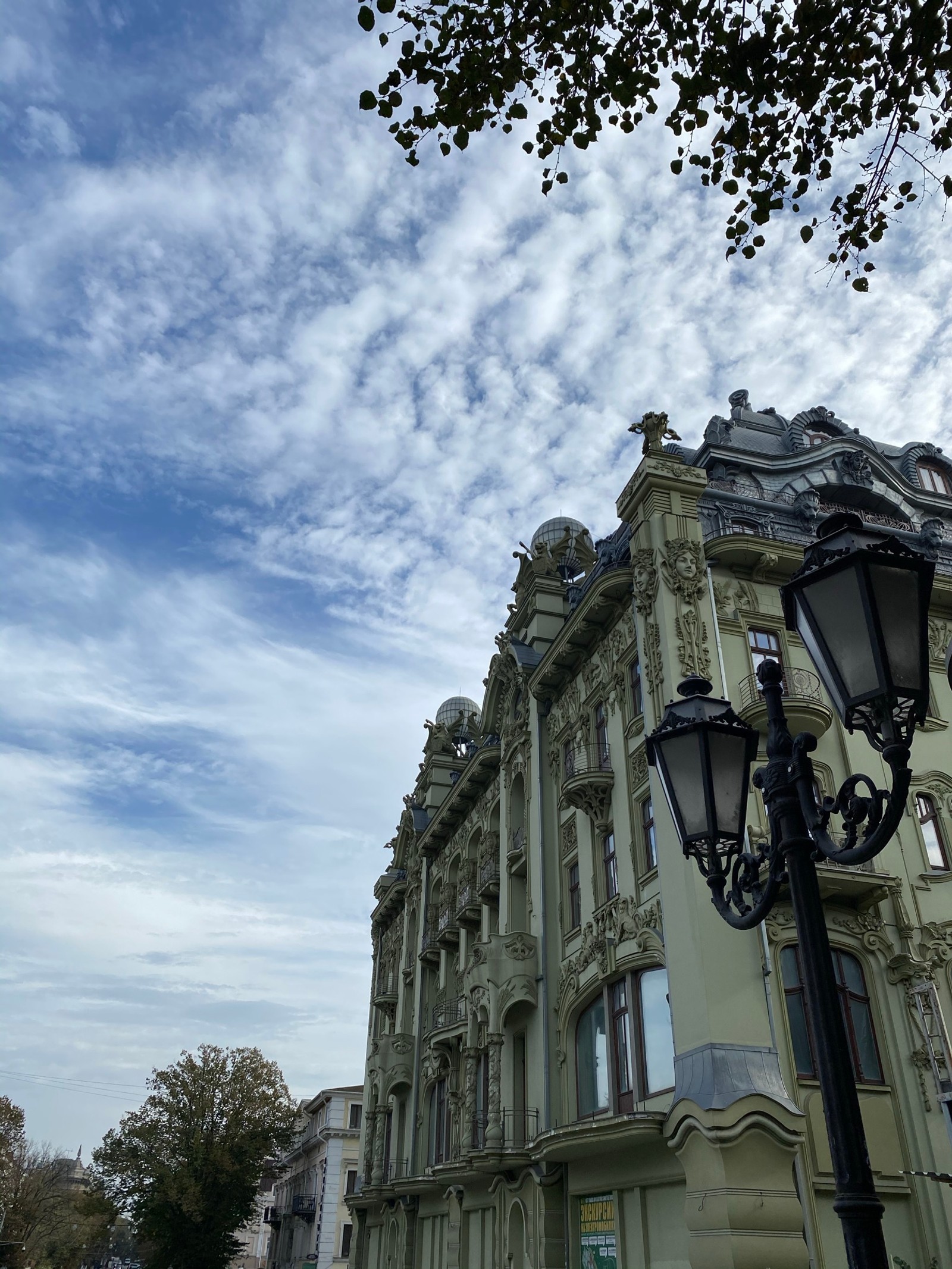 Há um poste de luz ao lado de um prédio (nuvem, vizinhança, fachada, poste de luz, luminária)