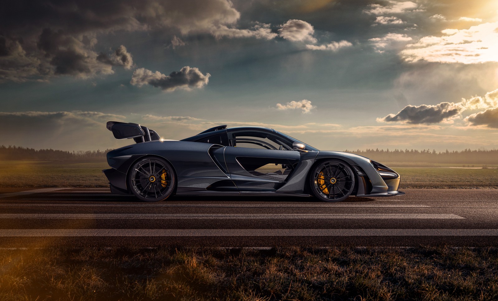 Um carro esportivo cinza dirigindo em uma estrada com céu nublado (mclaren senna, novitec, 2020, 5k, 8k)