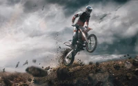 Freestyle-Motocross-Fahrer in Aktion vor dramatischem Himmel