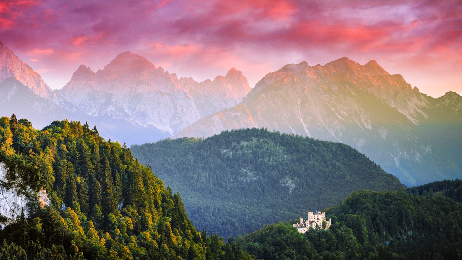 Um castelo fica no topo de uma montanha com um céu bonito (allgäu, alemanha, paisagem, cadeia de montanhas, castelo de neuschwanstein)