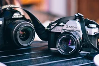 Canon and Nikon Cameras on a Table