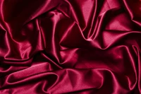 Tissu en satin rouge profond luxueux avec une texture de drapé doux