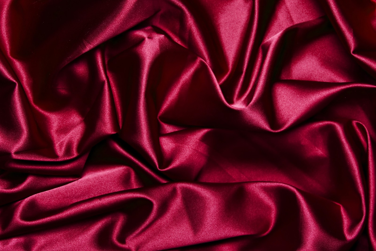 Close-up de um tecido de cetim vermelho com uma quantidade muito grande de pregas (satin, têxtil, seda, vermelho, veludo)