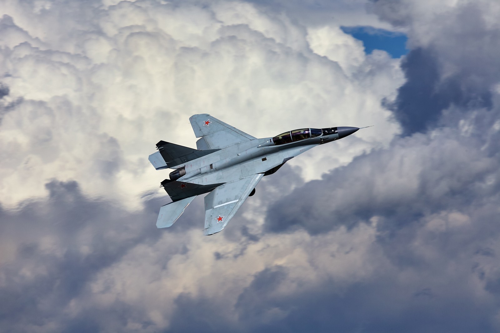 There is a fighter jet flying through the clouds in the sky (aircraft, airplane, air force, aviation, military aircraft)