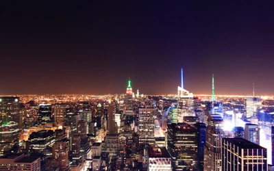 Impresionante vista aérea nocturna del horizonte de la ciudad de Nueva York iluminado por vibrantes luces de la ciudad