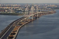 Vista aérea de uma ponte moderna conectando uma metrópole urbana sobre um rio.