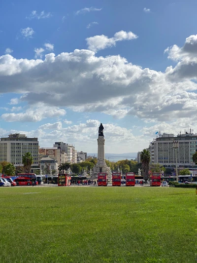 Городской парк с памятником и городским горизонтом под облачным небом