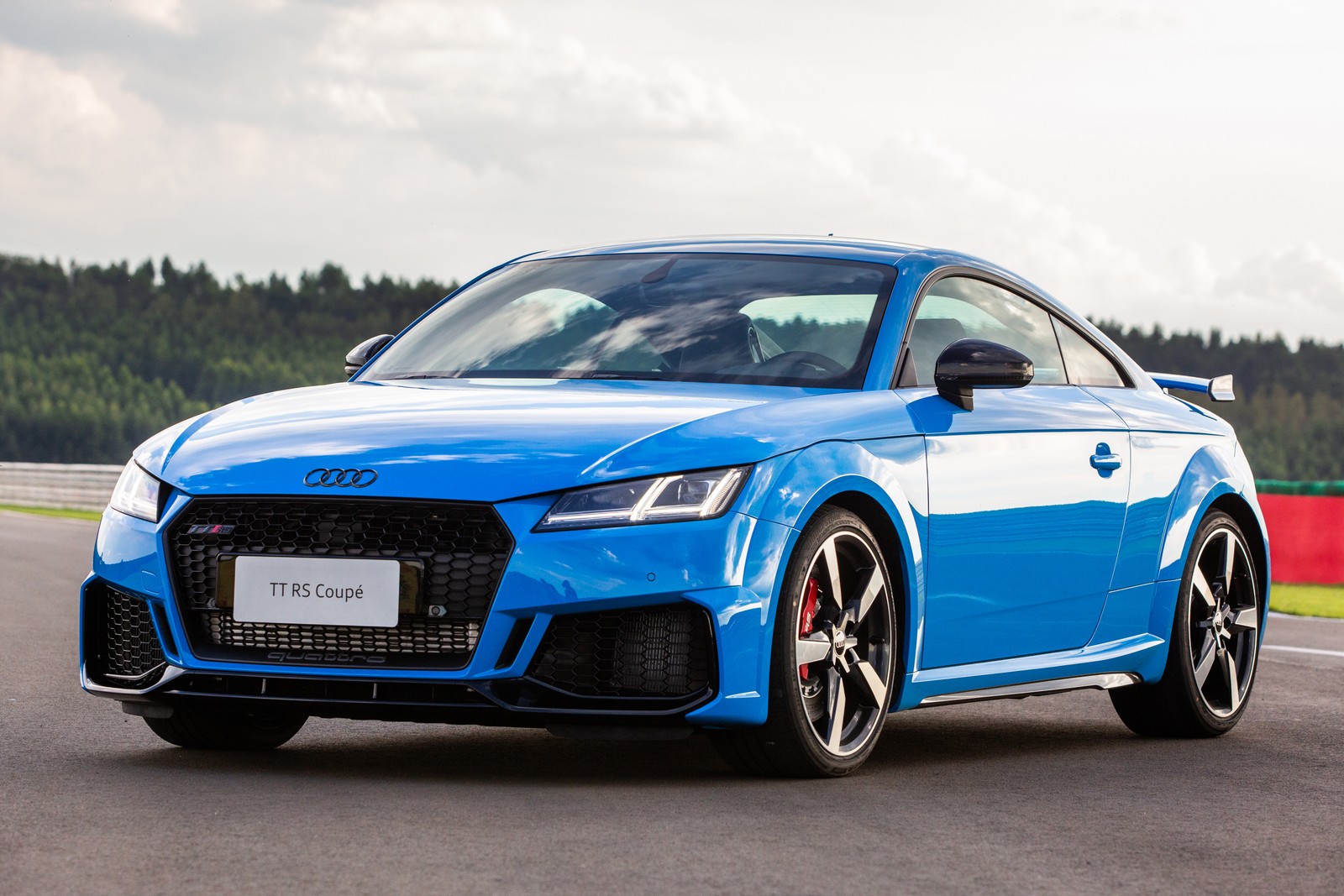 Ein blauer audi ttr auf einer strecke mit bäumen im hintergrund (audi tt rs coupé, 2021, 5k, autos, 4k hintergrund)