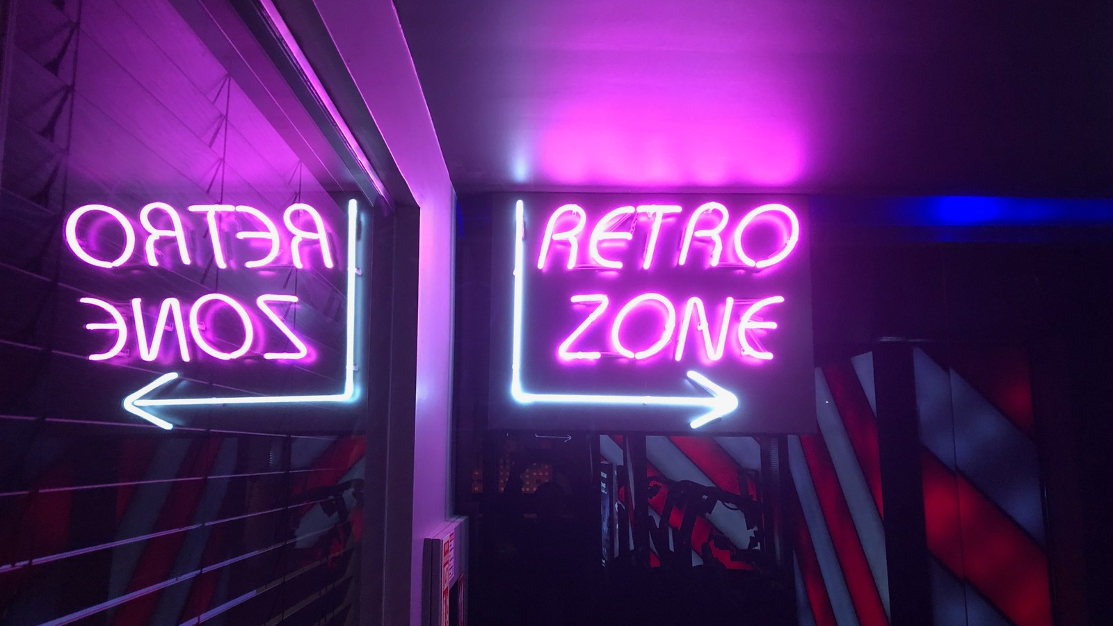 Placas de néon na vitrine de uma loja anunciando uma zona retrô (iluminação de efeitos visuais, texto, placa de néon, flecha, sinal)