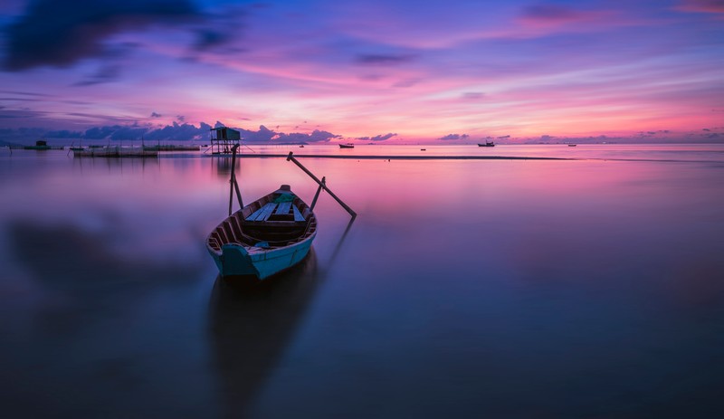 Арафированная лодка на воде на закате с фоном неба (phu quoc island, восход солнца, вьетнам, vietnam, фиолетовое небо)