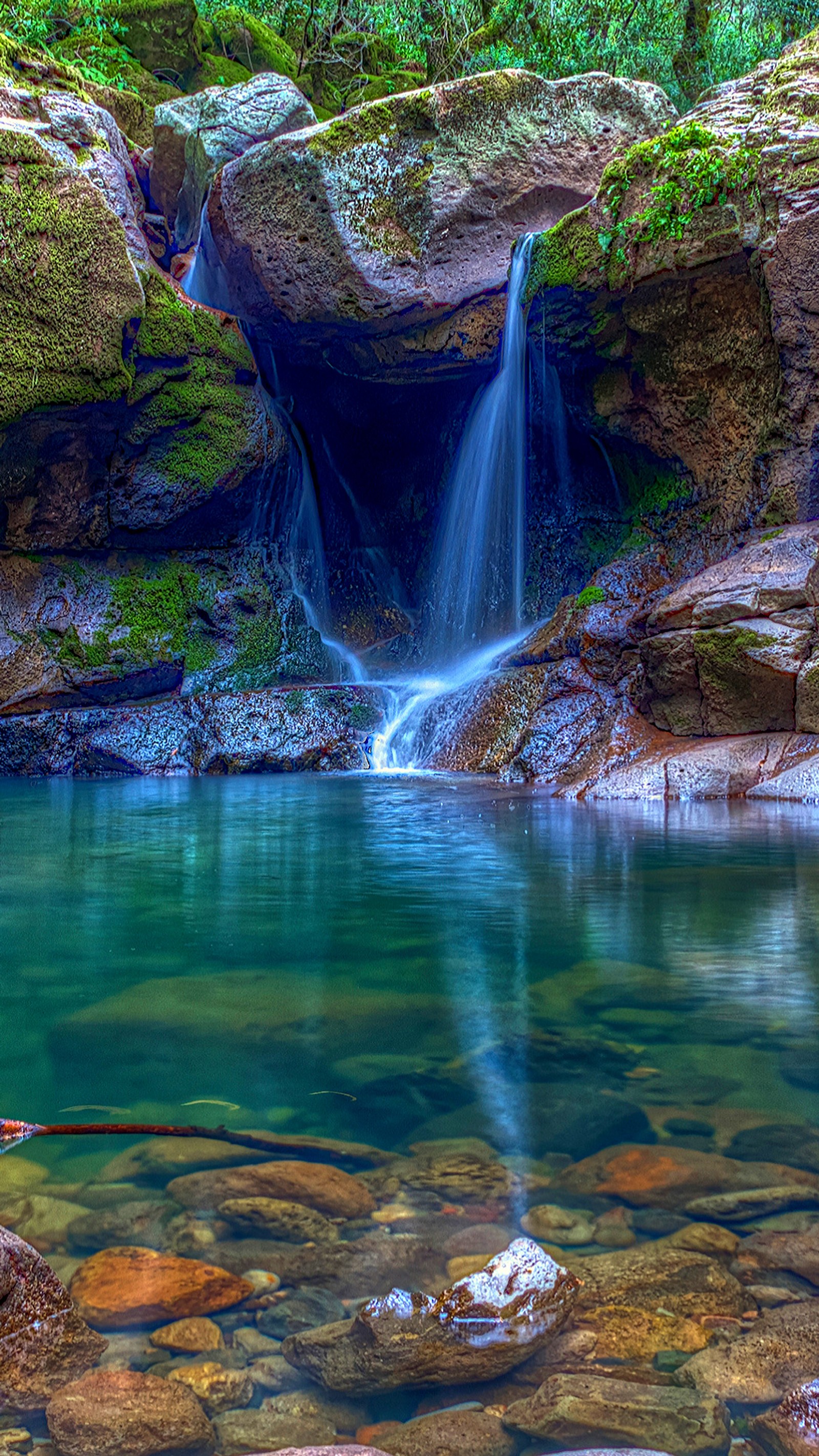 Una cascada que fluye sobre rocas en el agua (otoño, naturaleza, roca, piedra, agua)