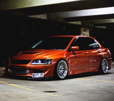 Mitsubishi Lancer Evolution con un acabado naranja elegante y ruedas personalizadas.