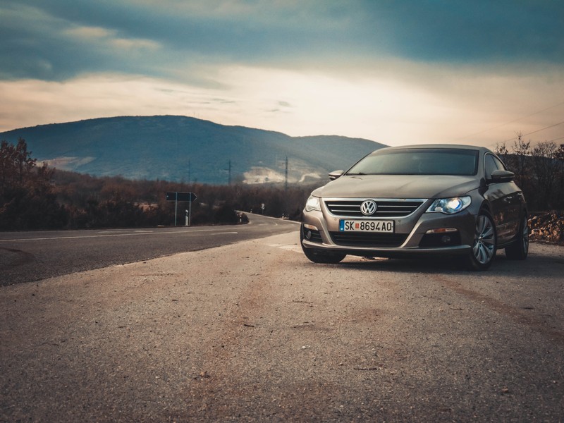 Крупный план автомобиля, припаркованного на дороге рядом с горой (gti, пассат, passat, пассат cc, passat cc)