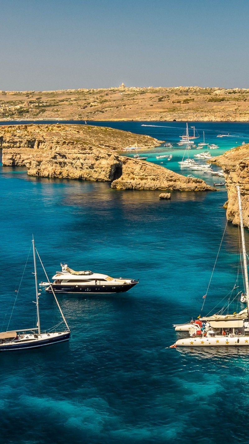 Несколько лодок на воде у скалистого берега (запуск, море)