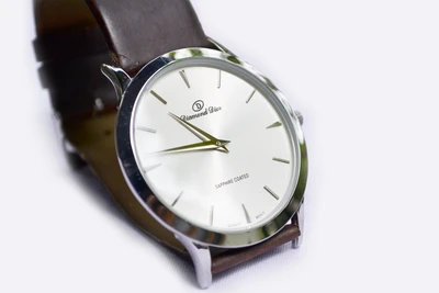 Reloj analógico elegante con correa de cuero marrón y esfera plateada