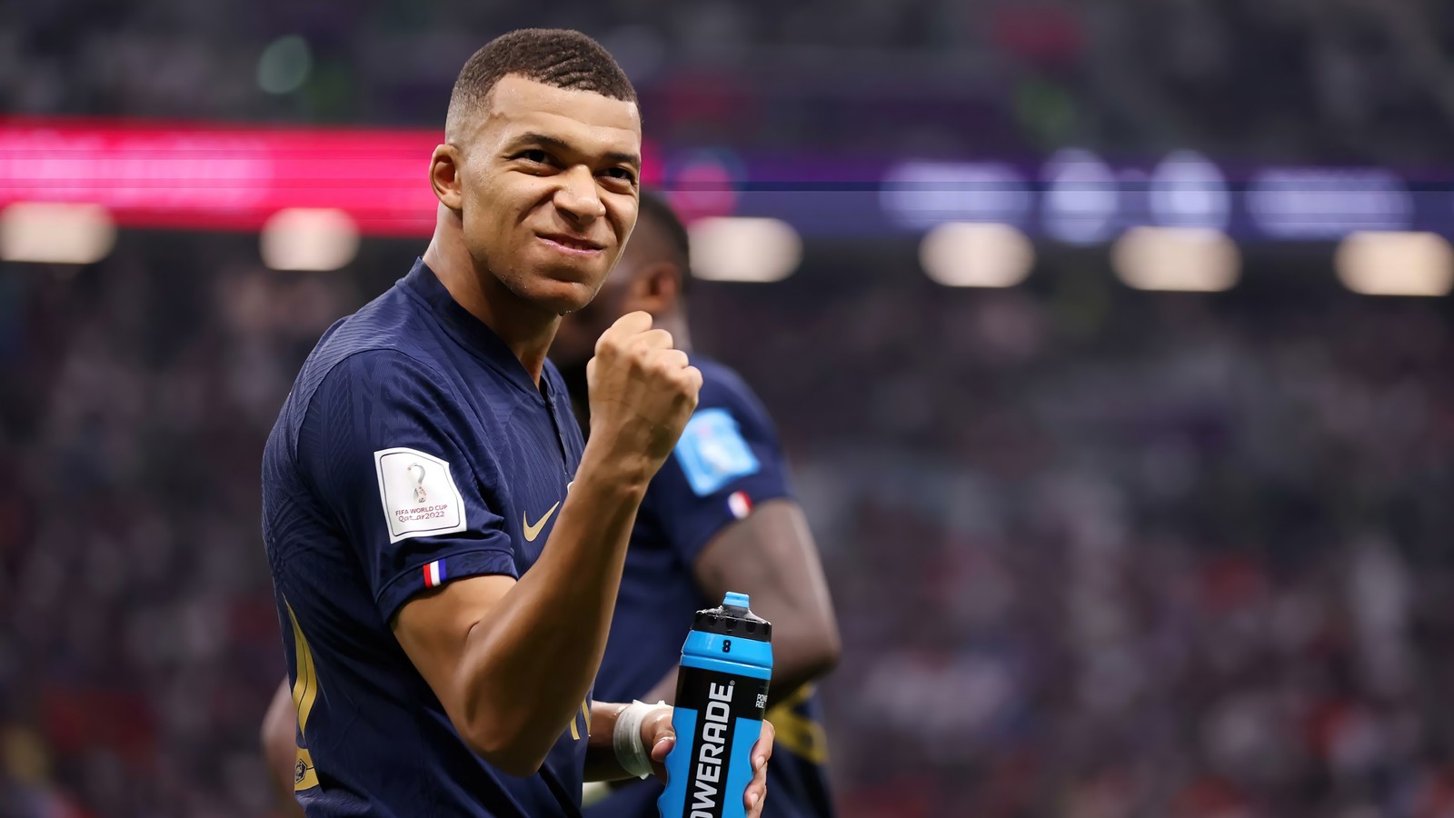 Un primer plano de un hombre sosteniendo una botella de agua (fútbol, deportes, kylian mbappé, kylian mbappe, francia)