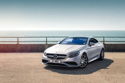 Elegante coupé Mercedes-Benz S63 AMG prateado com rodas de liga leve Brabus à beira-mar