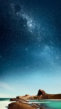 Starry Night Over Serene Sea and Rocky Shoreline