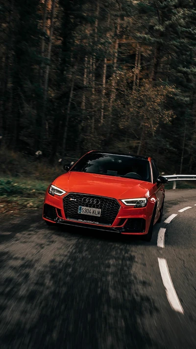 Audi RS3 dynamique en rouge vif filant sur une route forestière