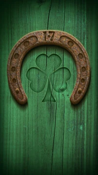 Rusty horseshoe with a clover design on a vibrant green wooden background.