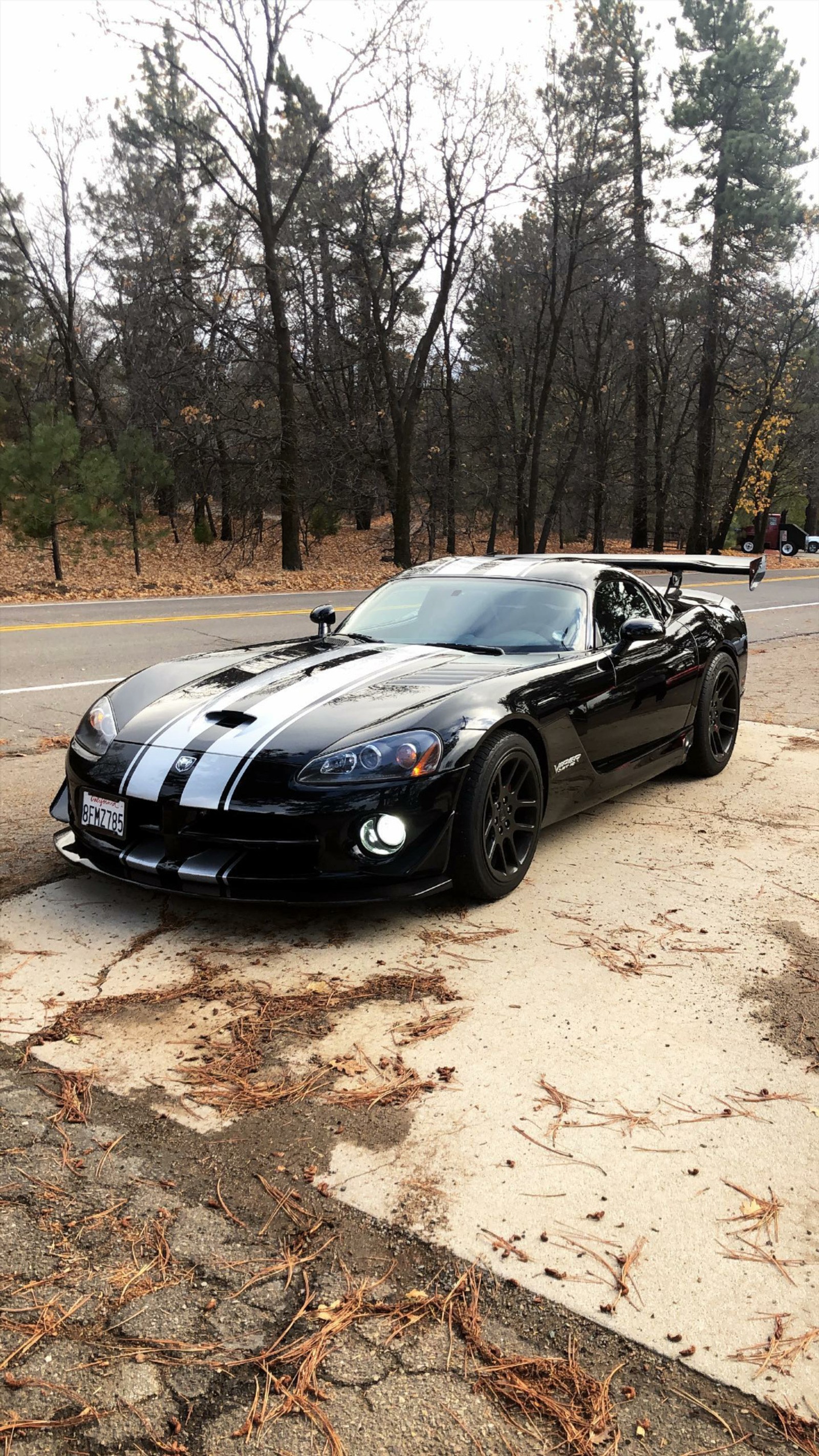 Une voiture de sport noire garée sur le bord de la route (dodge, vipère, noir, voiture, supersportive)