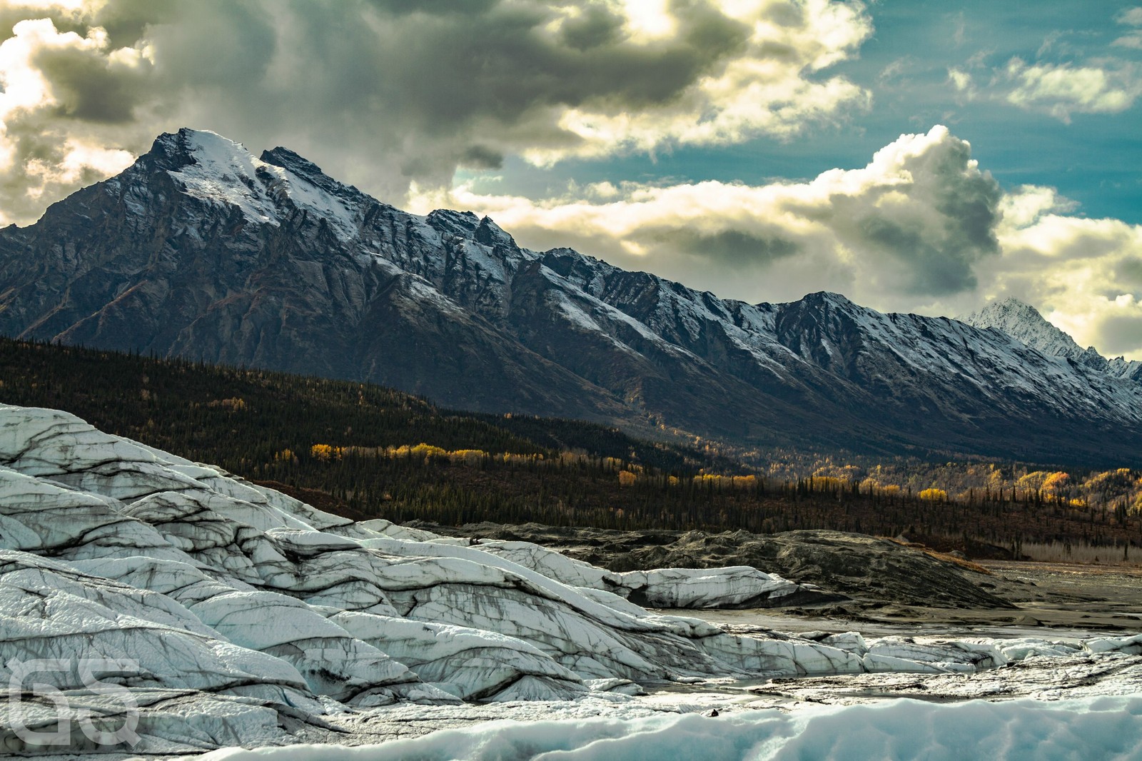 Montagnes et sol enneigé avec une rivière au premier plan (glacier, montagne, chaîne de montagnes, décor montagnard, vallée)