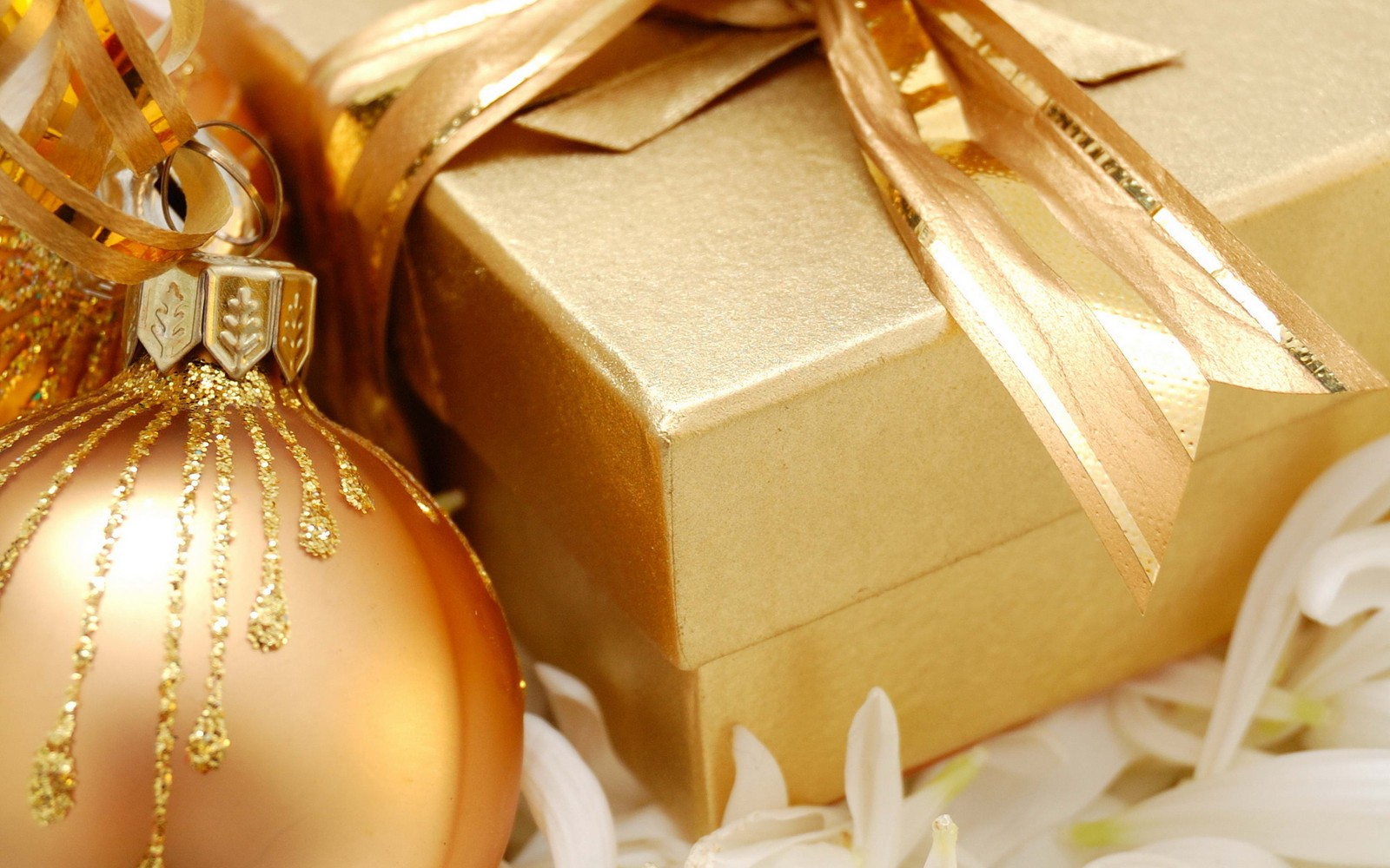 There is a gold ornament and a gold gift box (christmas gift, gift, gift wrapping, christmas day, present)