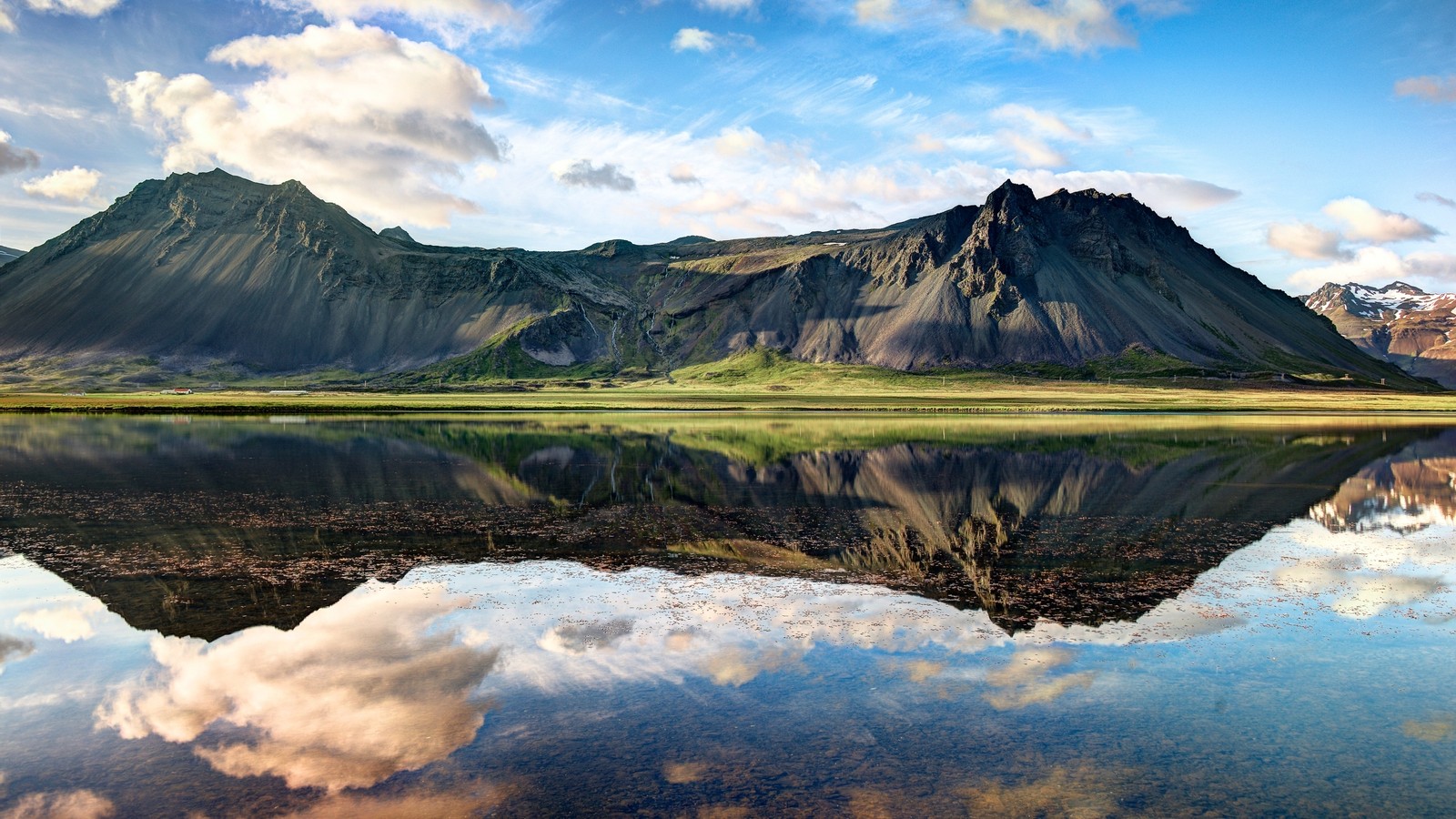 Montanhas refletidas em um lago com um céu nublado (reflexo, natureza, montanha, formas montanhosas, lago)