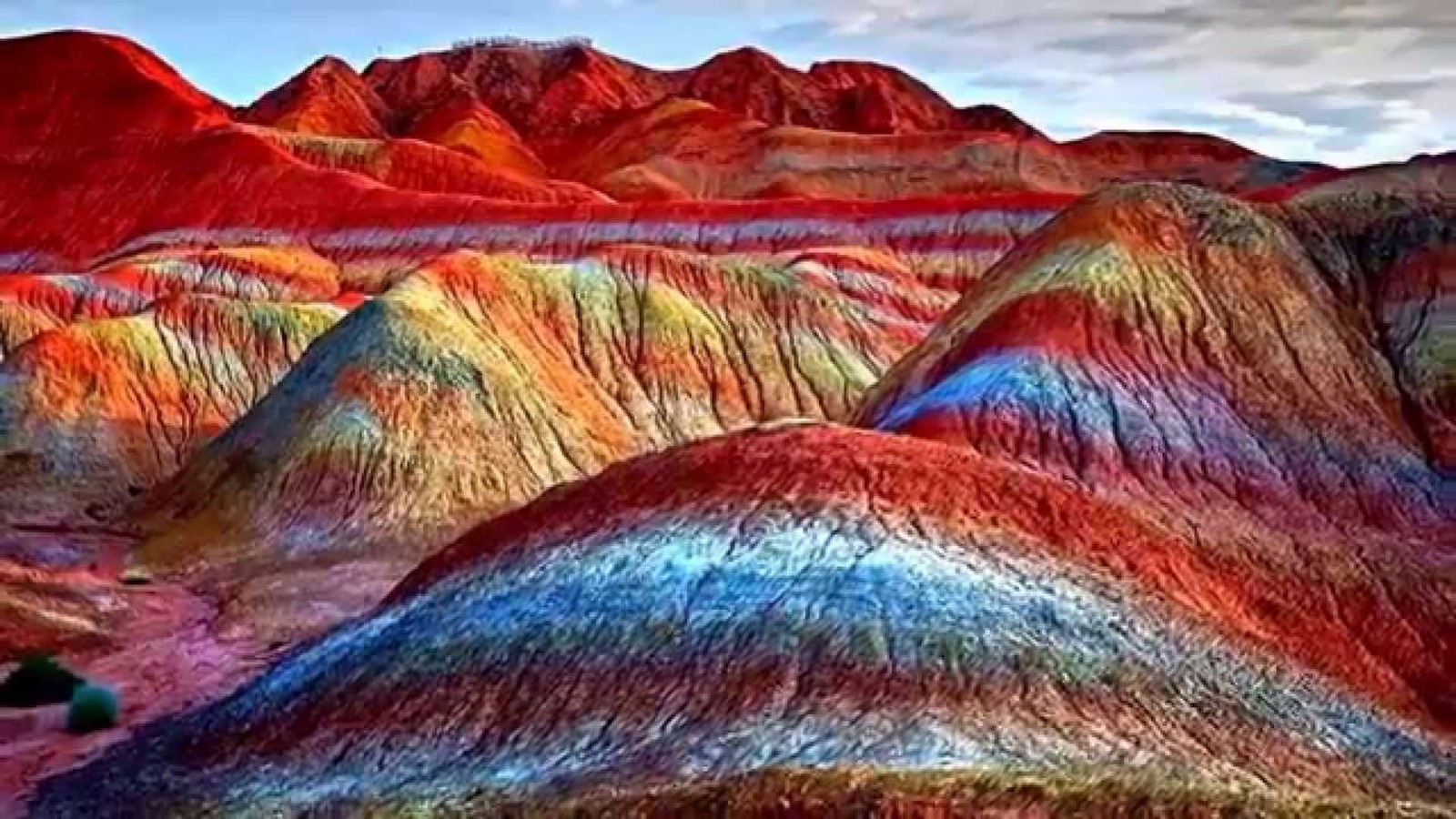 Arafed mountain with a rainbow colored landscape in the middle (mountain, rock, geology, badlands, landscape)