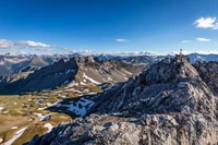 Paysage de montagne majestueux avec des sommets enneigés et un ciel bleu clair