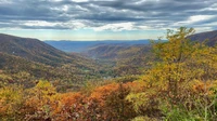 Paisaje vibrante de otoño en las tierras altas con montañas onduladas y cielo nublado