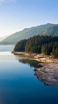 Lago tranquilo cercado por montanhas exuberantes e florestas de pinheiros em Seattle