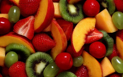 Ensalada de frutas vibrante con fresas, kiwi, duraznos y cerezas, que muestra una colorida y fresca variedad de ingredientes naturales.