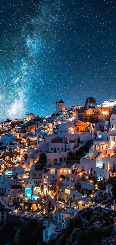 Encantadora paisagem noturna azul das casas iluminadas de Santorini sob um céu estrelado