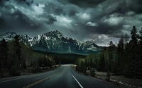 Stürmische Straße durch die kanadischen Rocky Mountains mit schneebedeckten Gipfeln