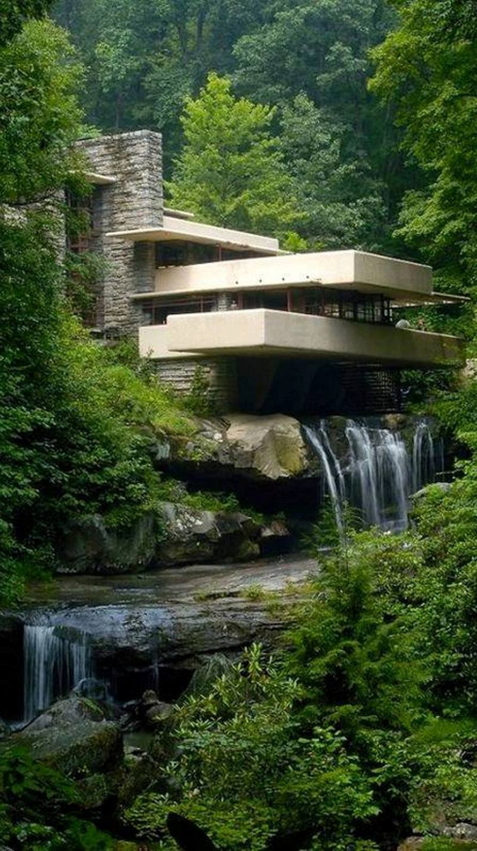 Un primer plano de una cascada frente a un edificio en el bosque (belleza, verde, casa, cascadas)