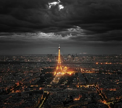 Tour Eiffel illuminée contre un ciel nocturne dramatique à Paris