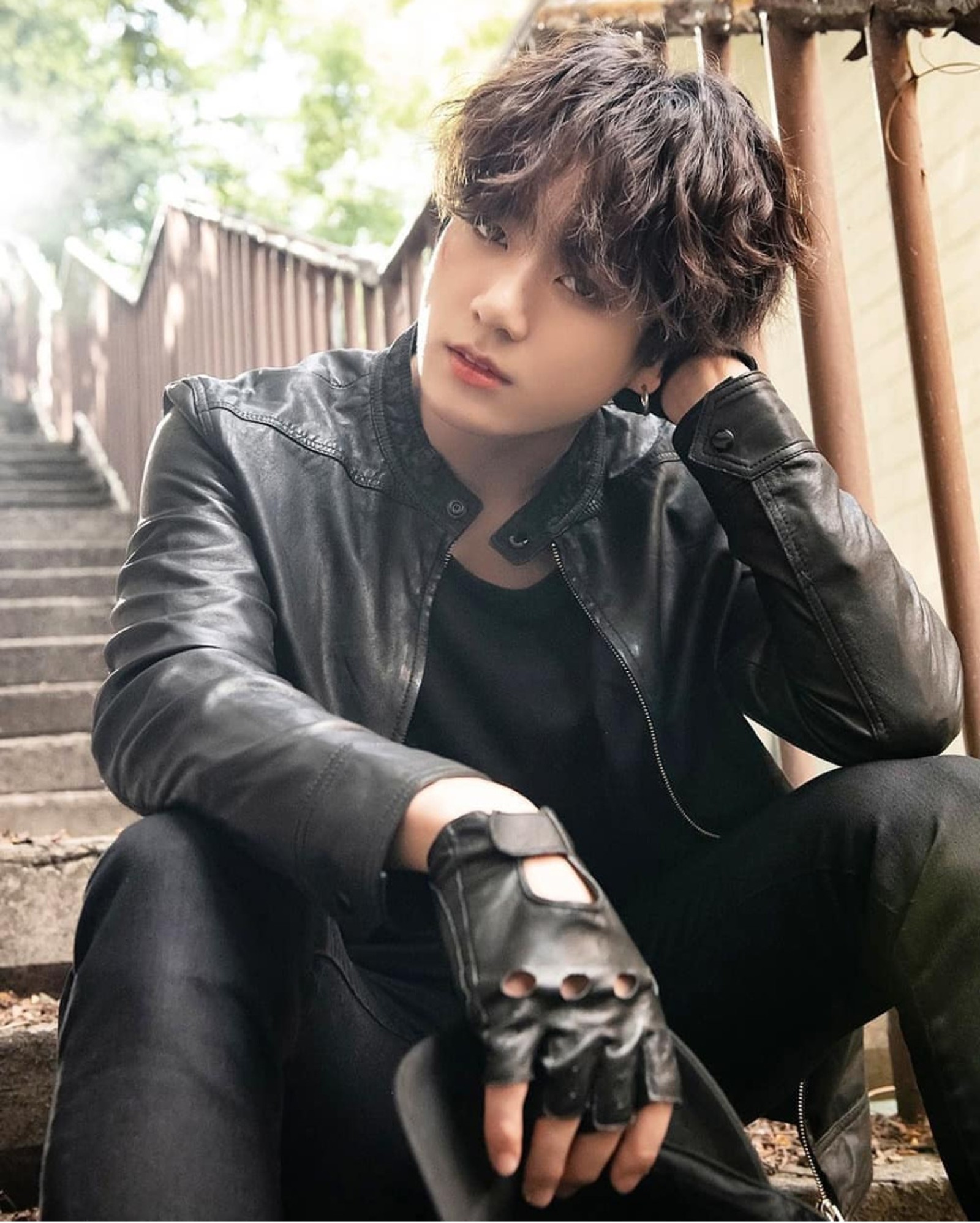 Arafed man sitting on steps with a leather jacket on (bts, jeon jungkook, jungkook, kookie)