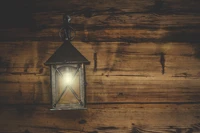 Rustic lantern casting a warm glow against a wooden backdrop.