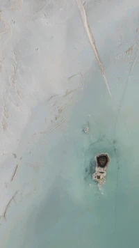 Aerial view of a small island surrounded by turquoise waters.