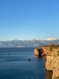 Lago de alta montaña sereno con majestuosas montañas en el cielo azul