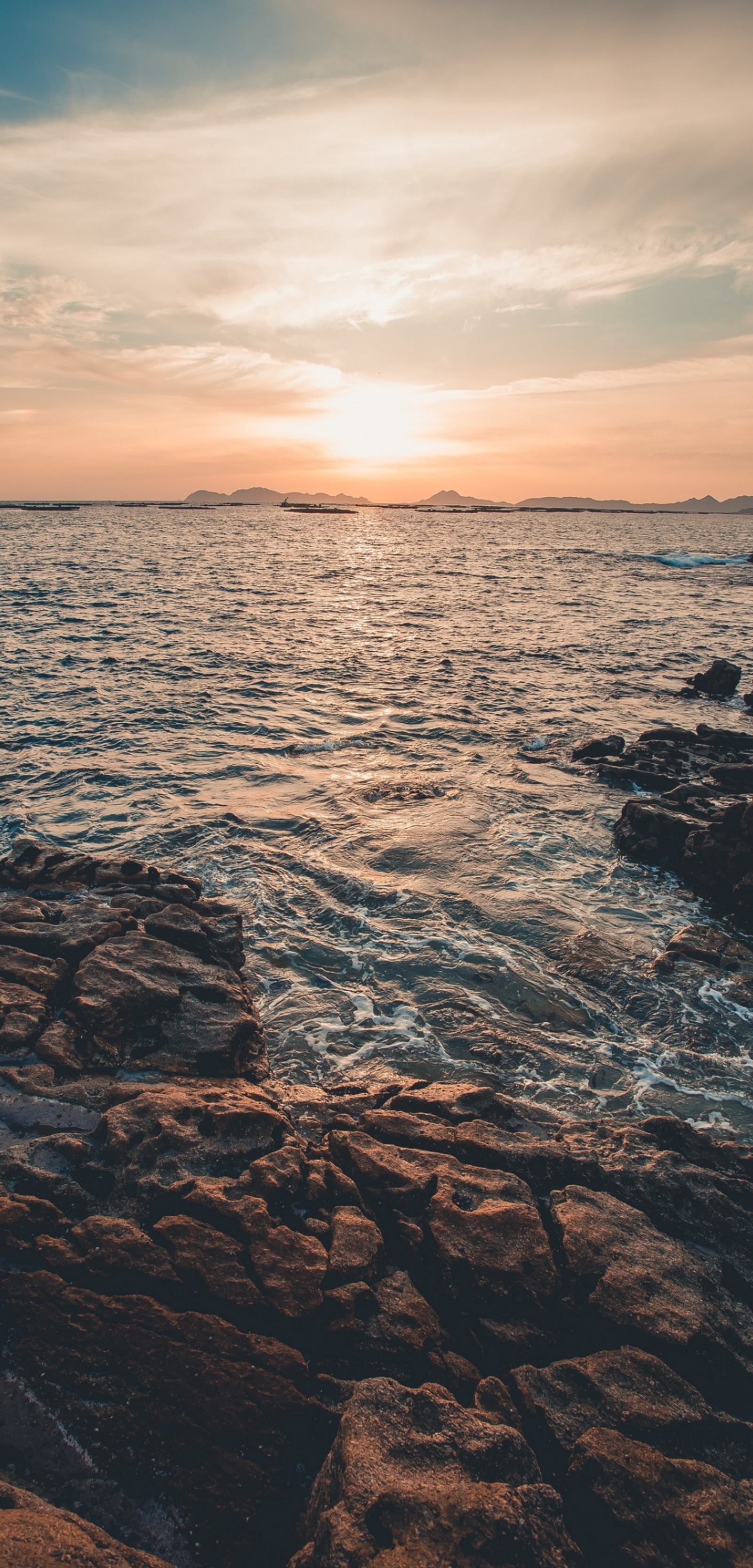 Vue arrafée d'un coucher de soleil sur l'océan avec des rochers (mer, coucher de soleil, horizon, nature, roche)